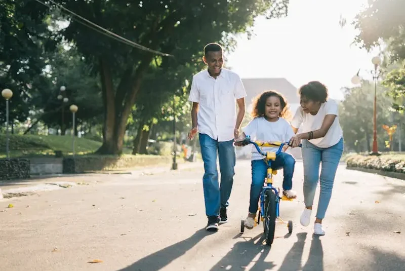 family teaching their child to ride a bike