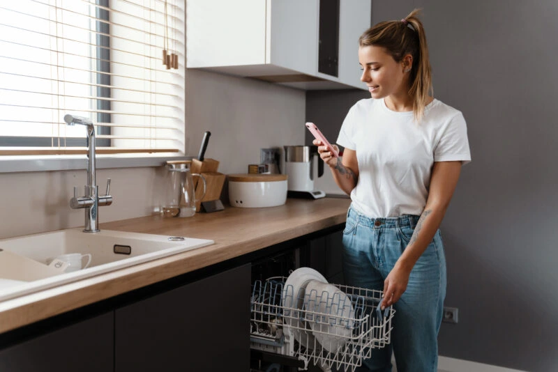 woman in the kitchen looking at her phone