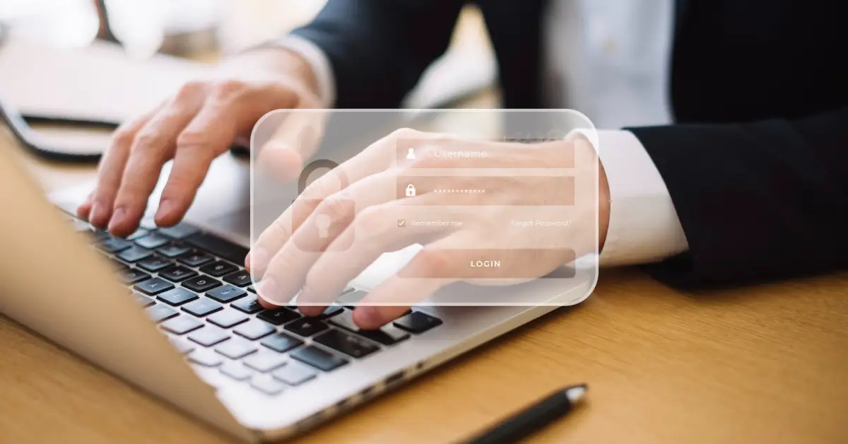A close-up of hands typing on a laptop keyboard, with an overlayed login form for username and password entry.